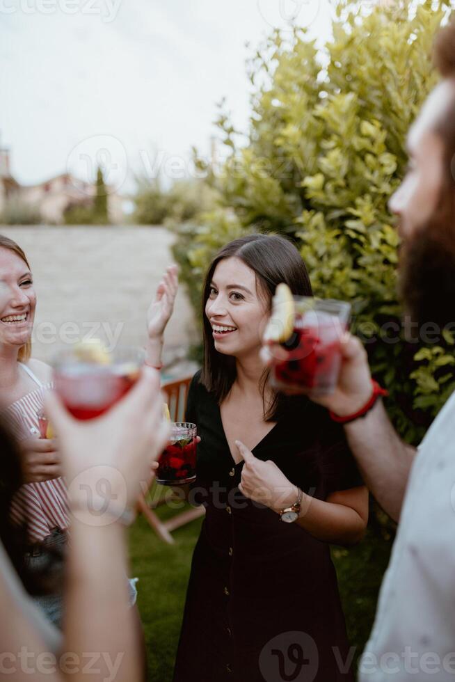 Group of cheerful friends clinking glasses at party. photo