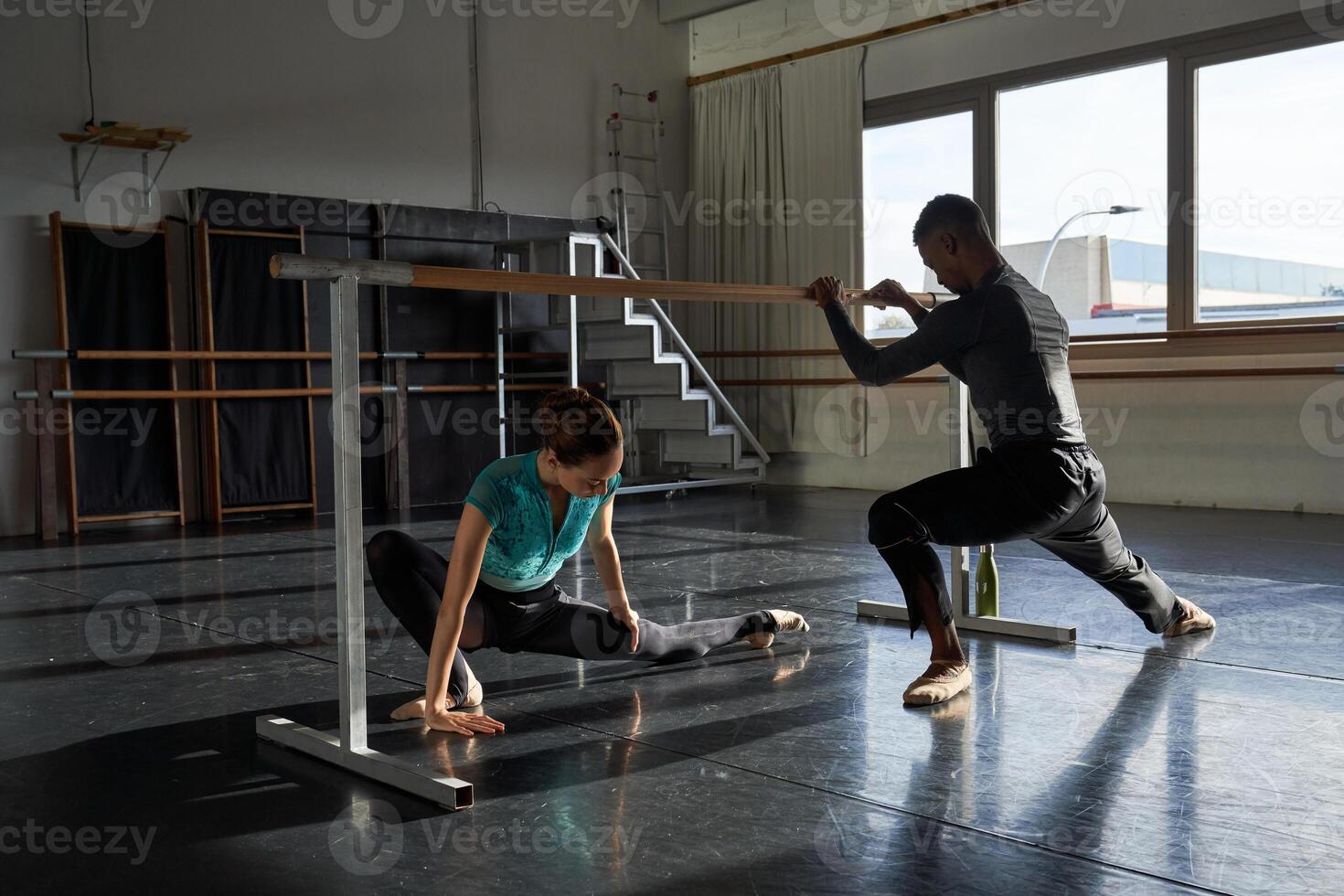 Two people in a dance studio practicing on a bar photo