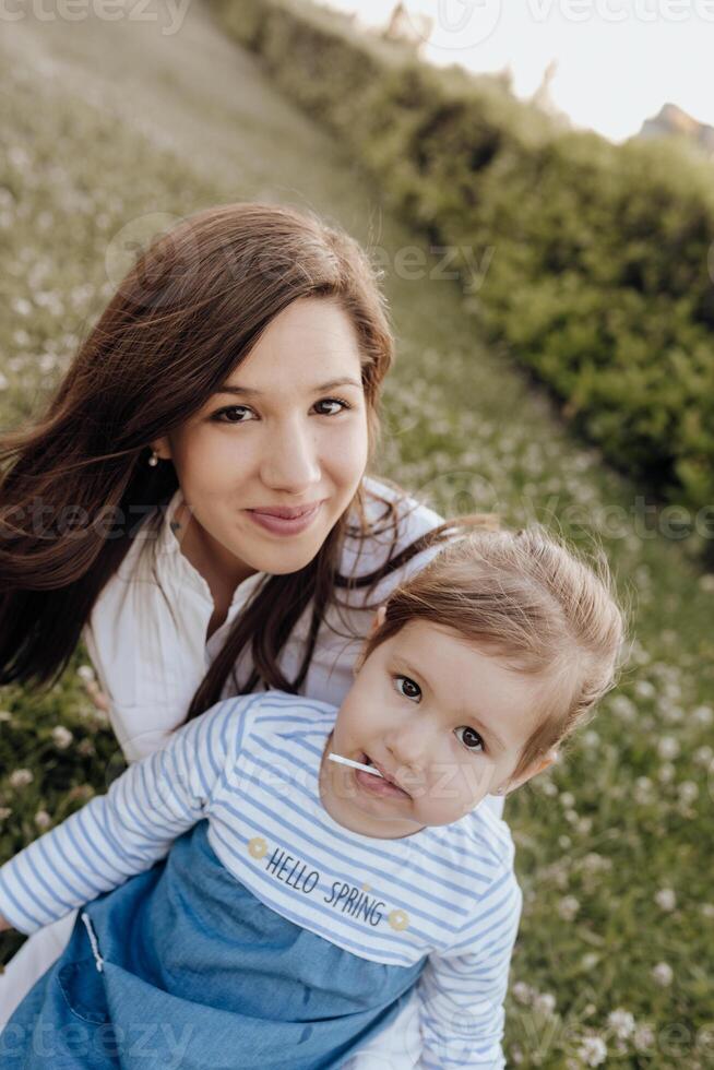 A woman and her child are sitting in the grass photo