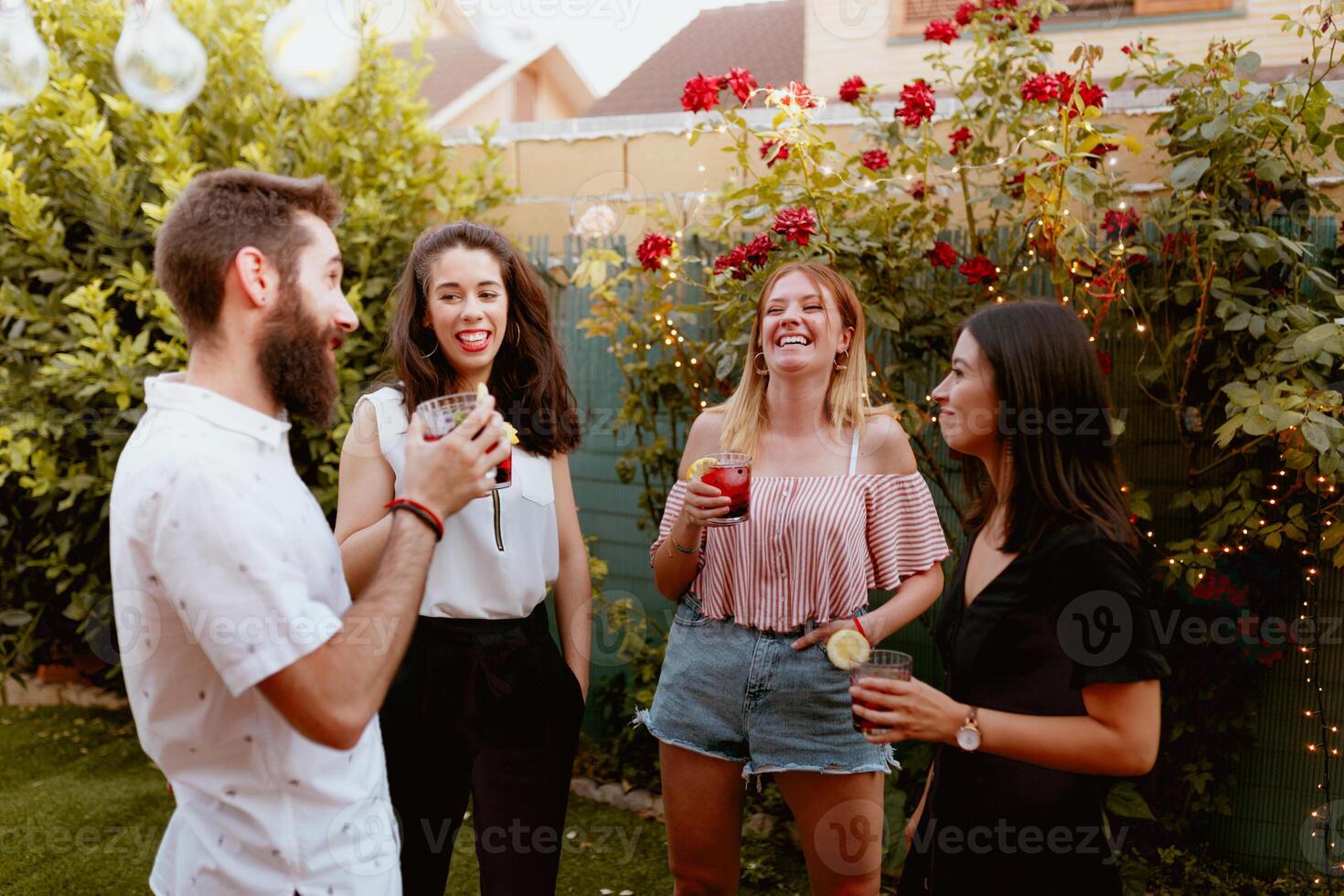 Four friends having a drink in the backyard photo
