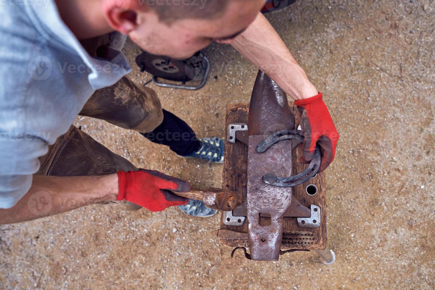 A man is using a hammer to make a piece of metal photo