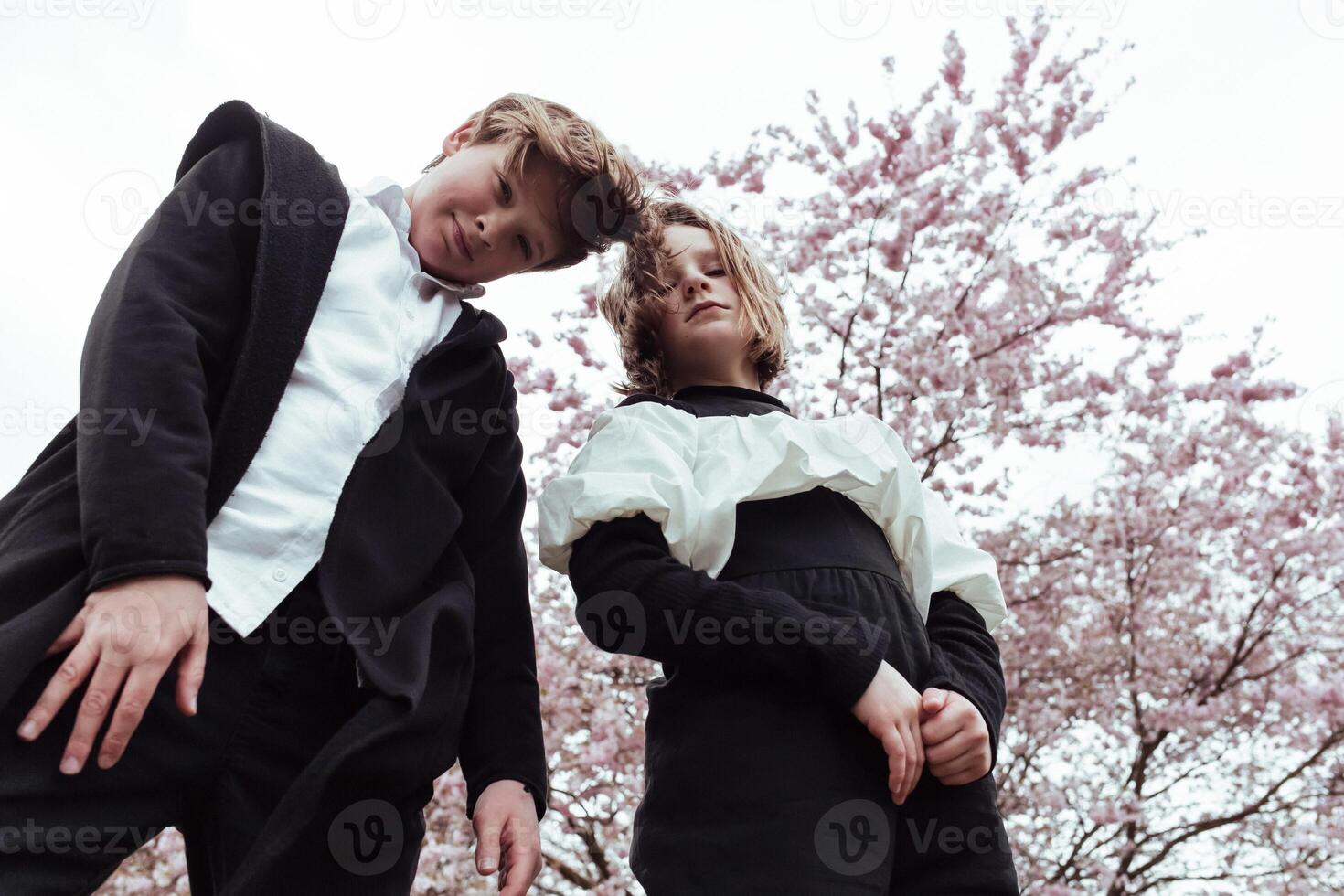 Two young people standing in front of a tree photo