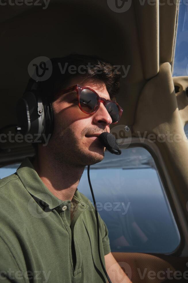 A man wearing sunglasses and a headset in a plane photo