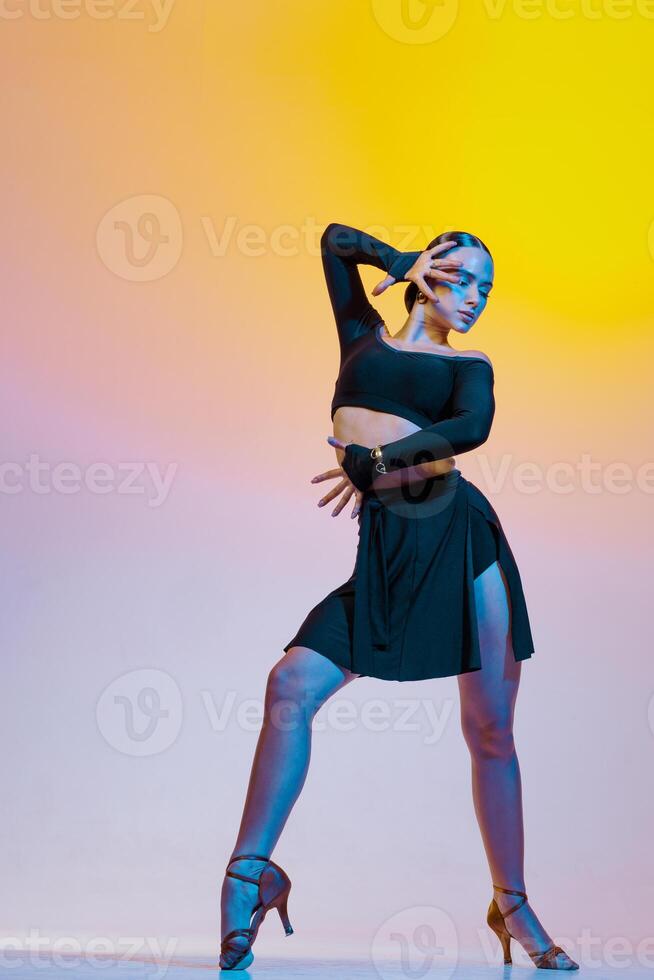 Graceful dancer in black clothes dances Latin American dances on a bright gradient background. photo