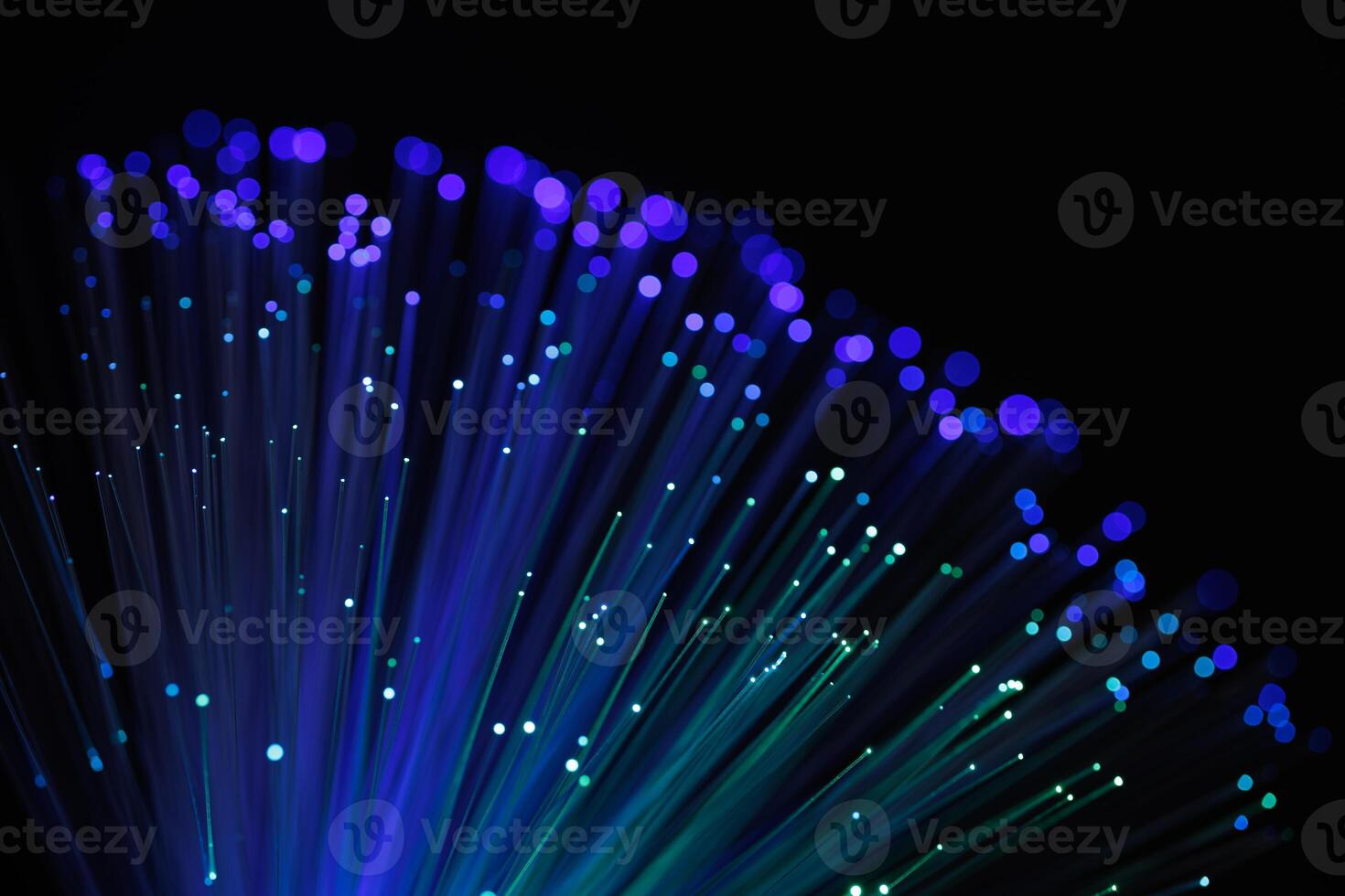 Glowing fiber optic cables with vibrant blue and purple bokeh lights on a dark background, representing fast internet, data transfer, and technology photo