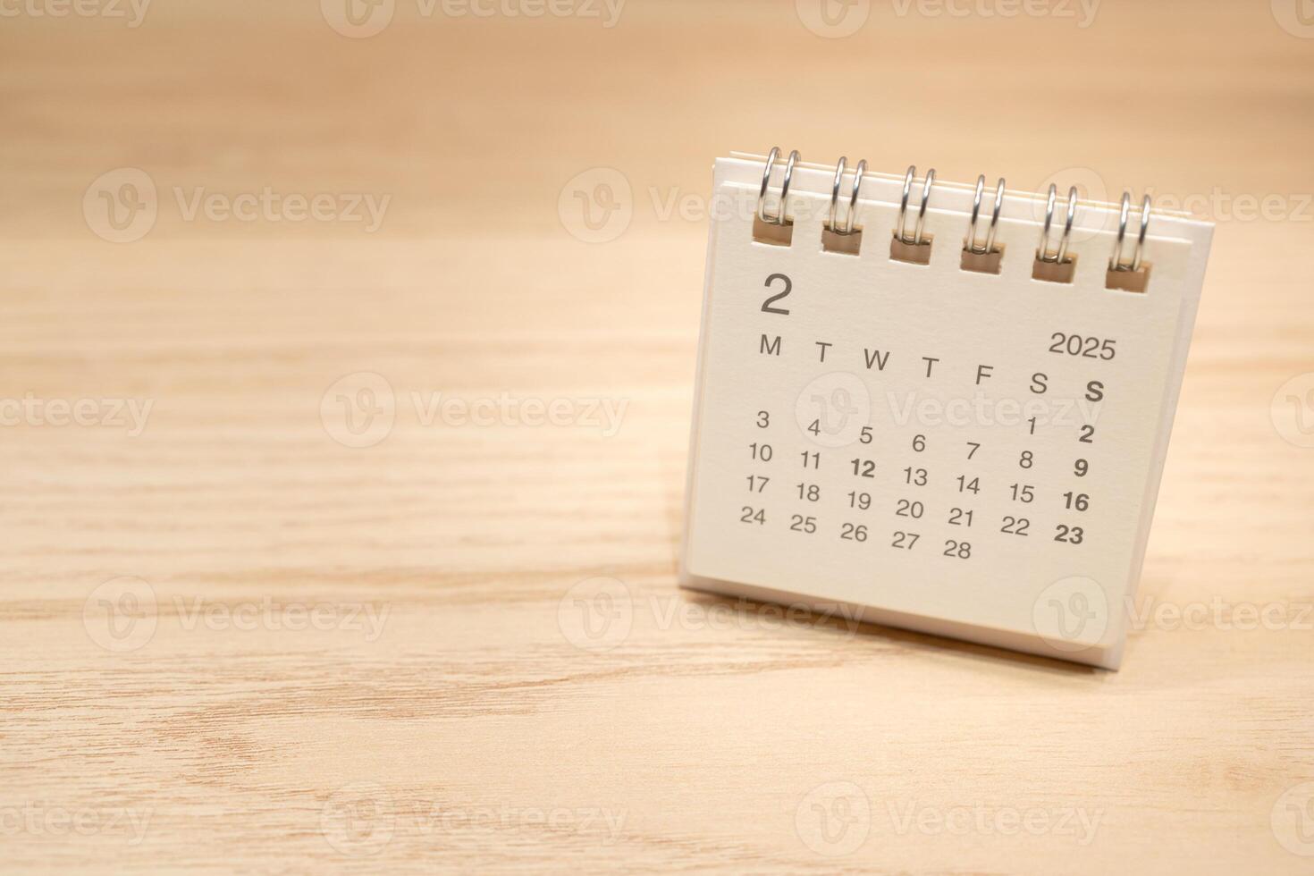 Desk Calendar for FEBRUARY 2025 background. Calendar concept with 2025 FEB calendar on wooden background. Copy Space for text. photo