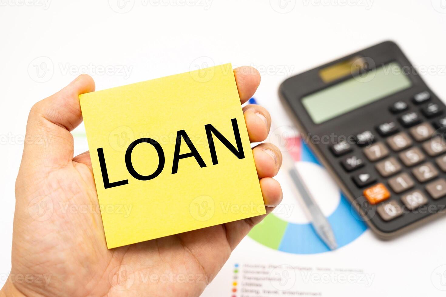 LOAN word on sticky note with calculator and graph. Real estate market and finance concept. photo