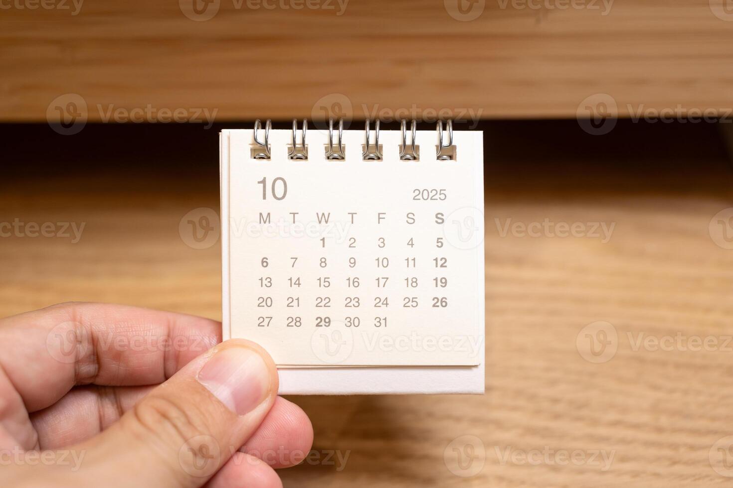Desk Calendar for OCTOBER 2025 background. Calendar concept with 2025 OCT calendar on wooden background. photo
