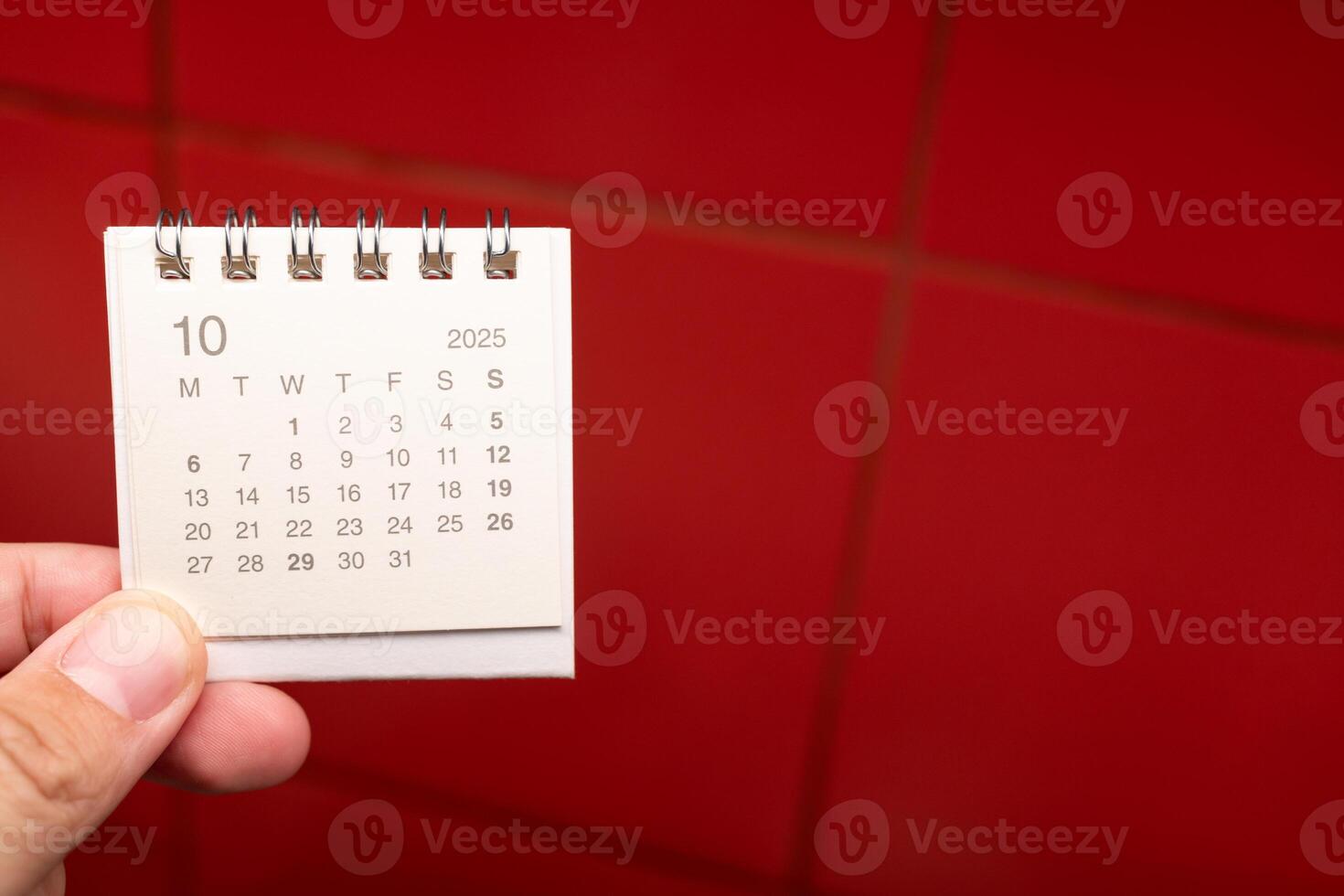 Desk Calendar for OCTOBER 2025 background. Calendar concept with 2025 OCT calendar on red background. photo