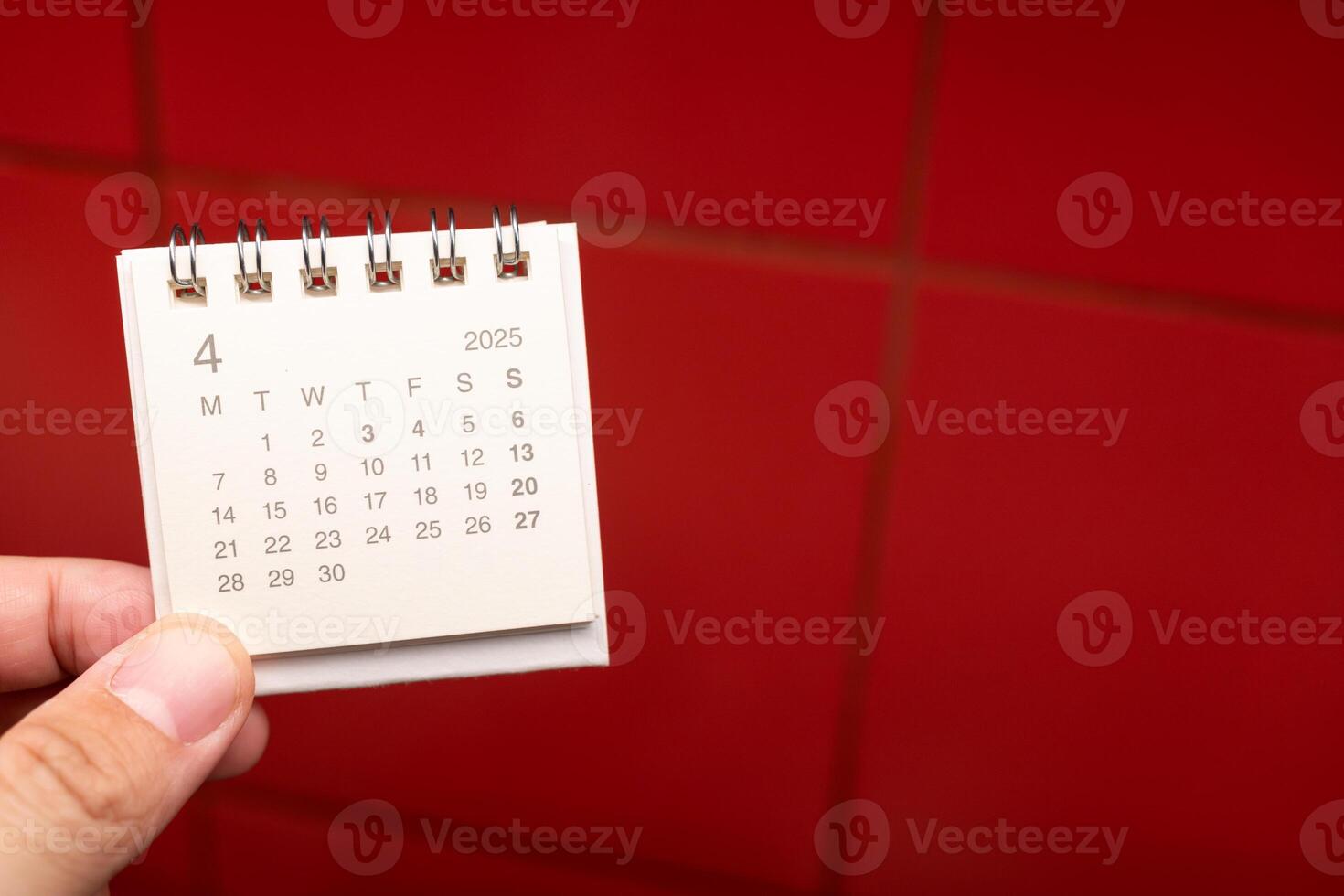 Desk Calendar for APRIL 2025 background. Calendar concept with 2025 APR calendar on red background. photo