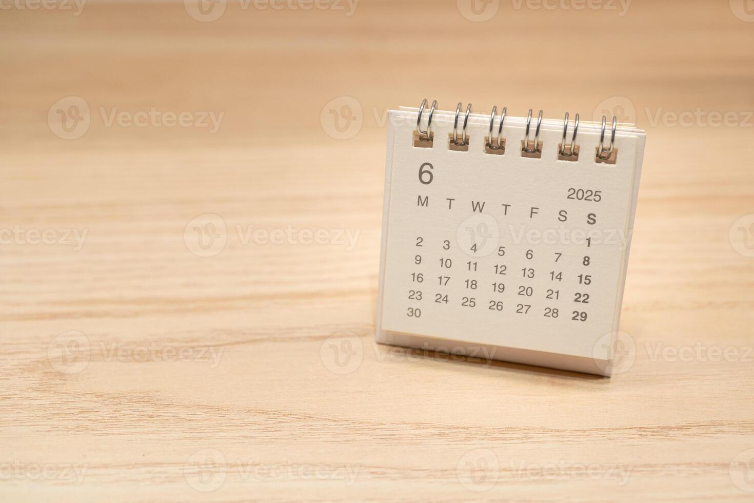 Desk Calendar for JUNE 2025 background. Calendar concept with 2025 JUN calendar on wooden background. Copy Space for text. photo