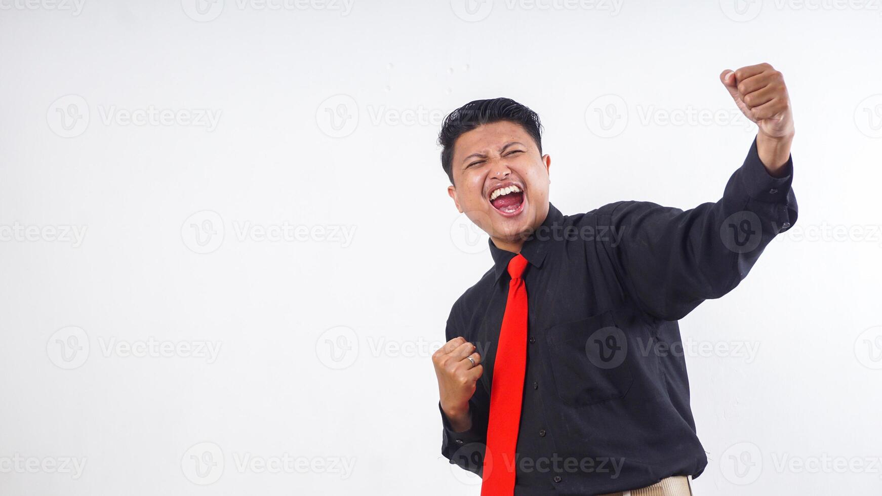Happy excited Asian man in formal clothes celebrating success isolated on white background photo