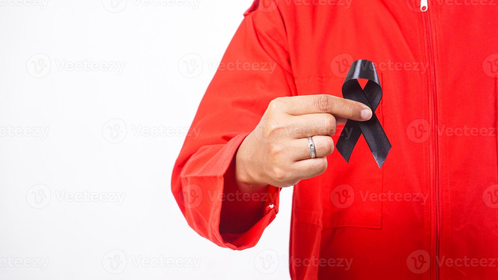 Close up of man holding black ribbon on his chest as symbol of mourning and melanoma cancer awareness isolated on white background photo