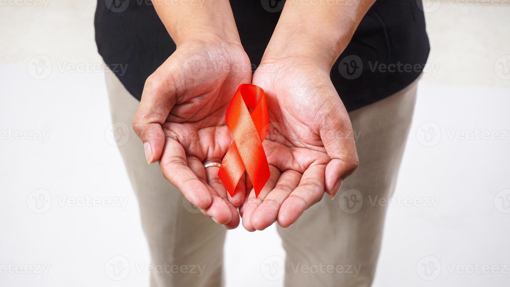 Red ribbon awareness in man hands isolated on white background photo