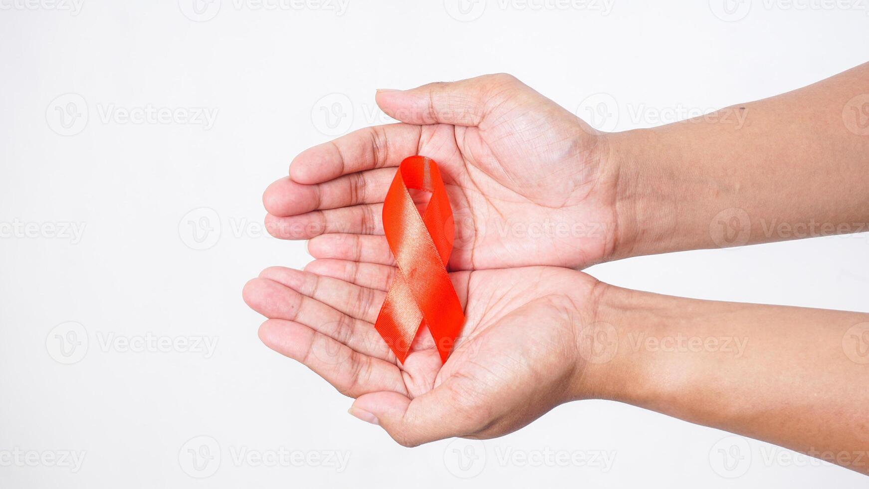 Hands showing red awareness ribbon on palm on white background photo