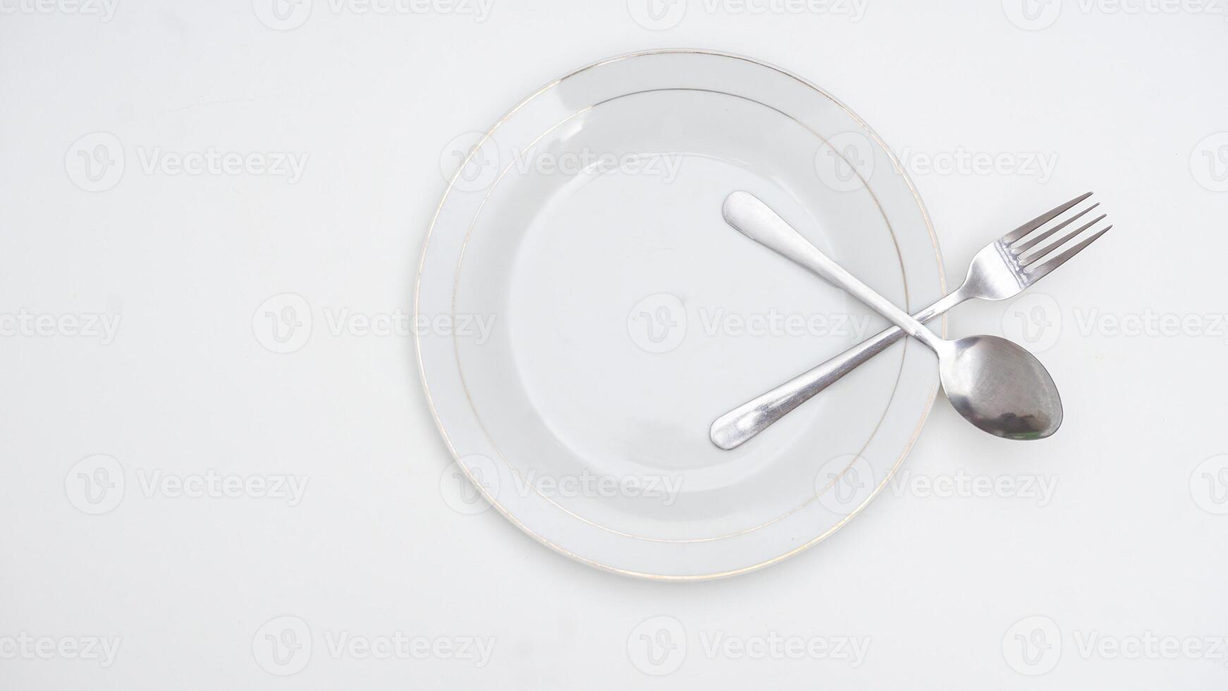 Spoon and Fork on a Plate Isolated on White Background photo