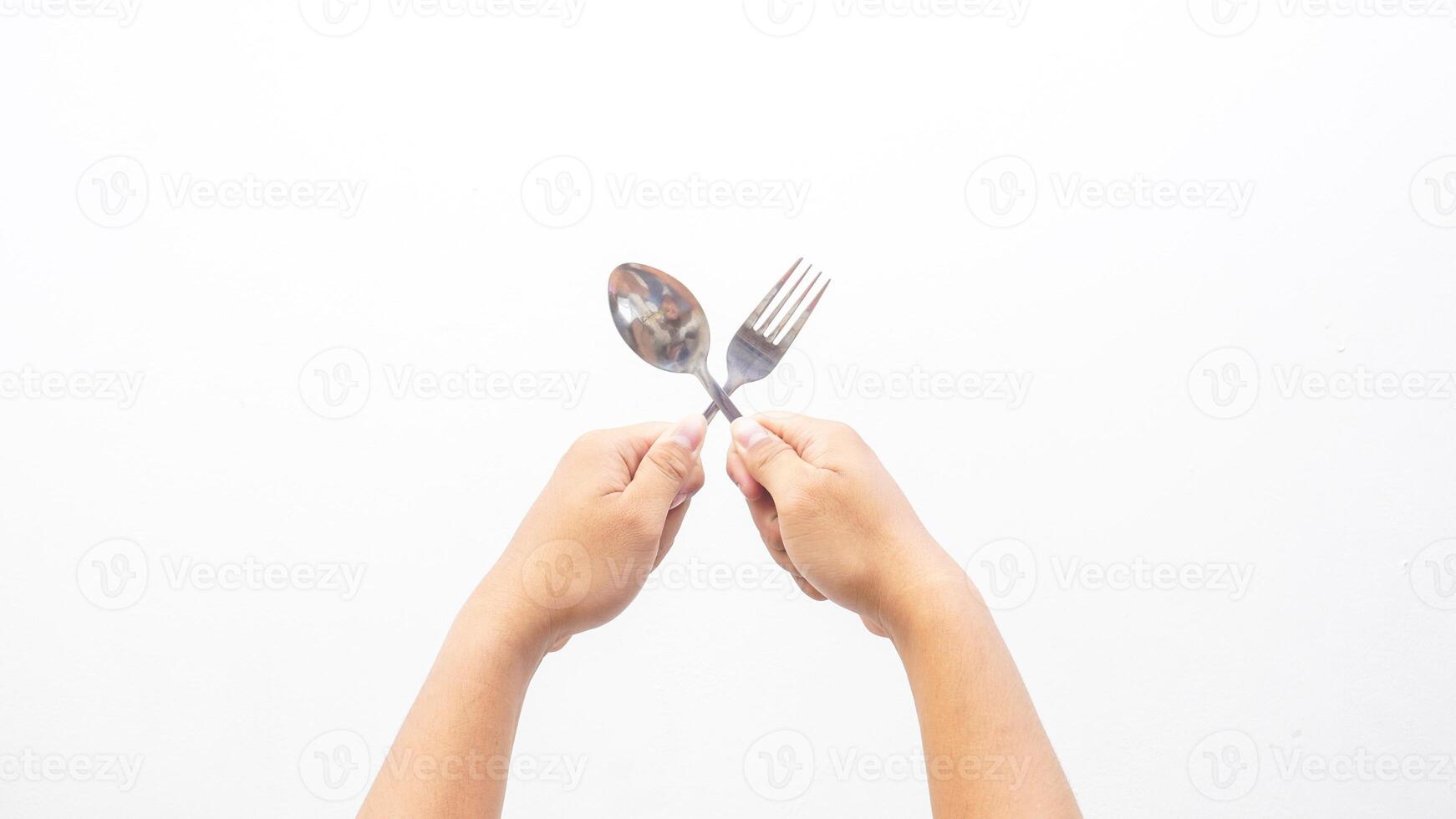 Hands Holding Silver Stainless Spoon and Fork Isolated on White Background photo