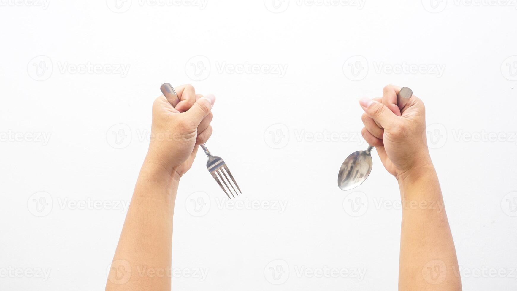 Hands of Man Holding Stainless Steel Spoon and Fork Isolated on White Background photo