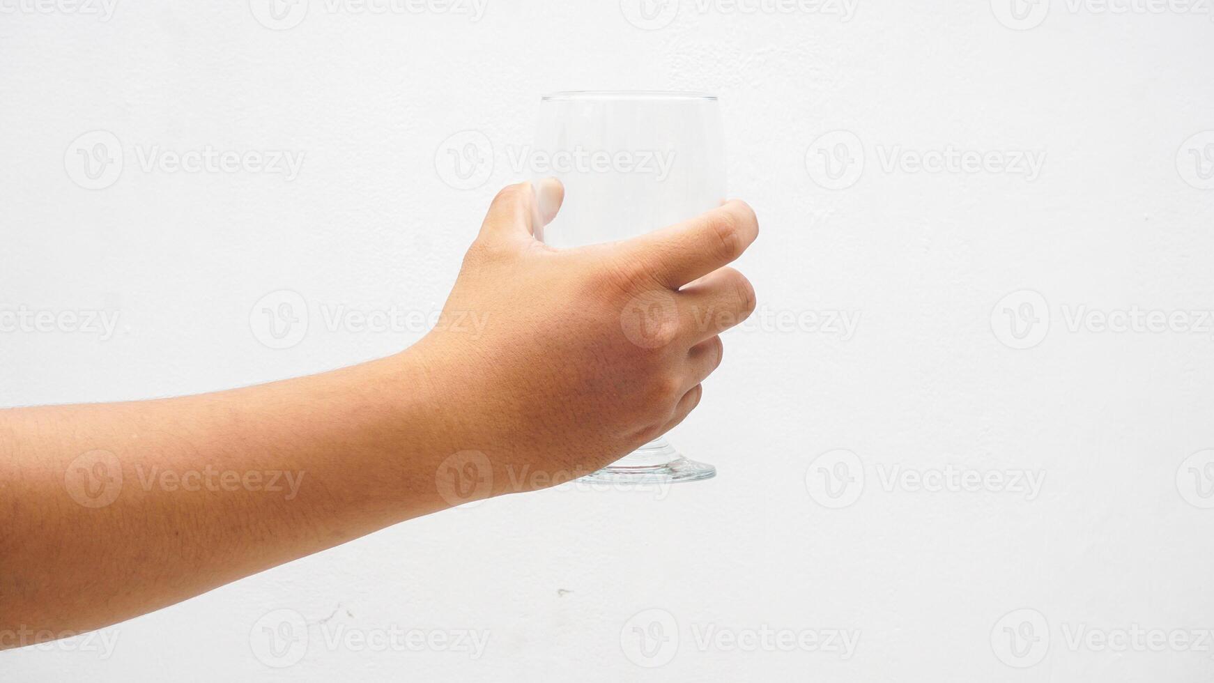 Hand Holding Transparent Glass Isolated on White Background photo