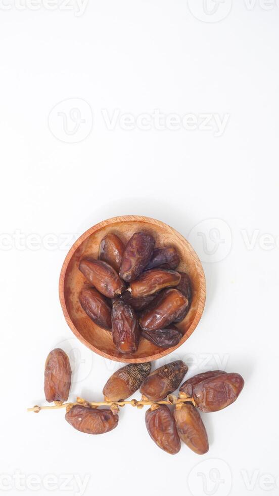 Soft Chewy Dried Dates Fruit on Wooden Plate for Iftar Isolated on White Background photo