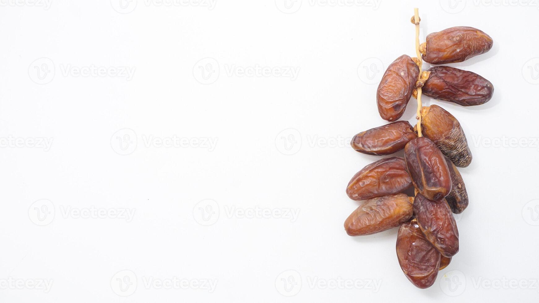 Nutritious Dried Dates Fruit on Stalk Perfect Iftar Sweet Snack Isolated on White Background photo