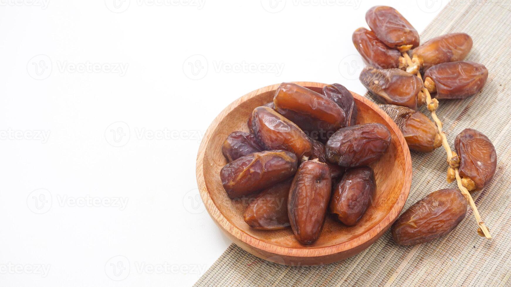 Delicious Nutritious Dried Dates Fruit on Wooden Plate Ramadan Isolated on White Backgrou photo