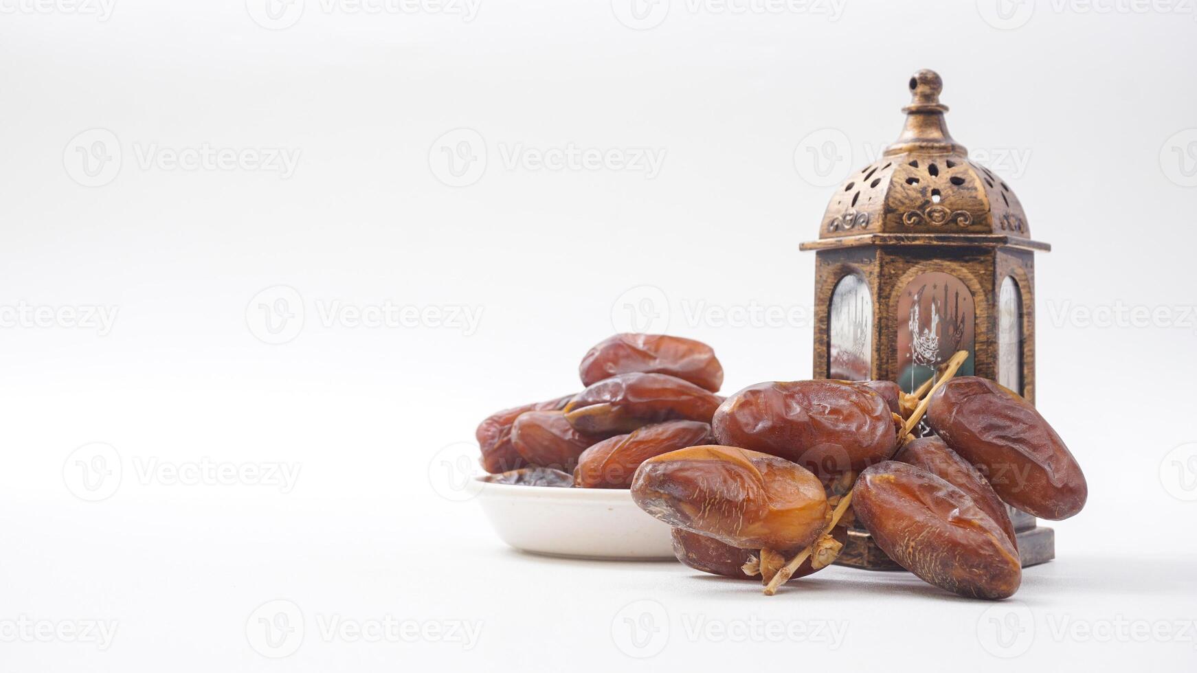 Delicious Dates Fruit on Bowl for Ramadan Iftar with Islamic Lantern Isolated on White Background photo
