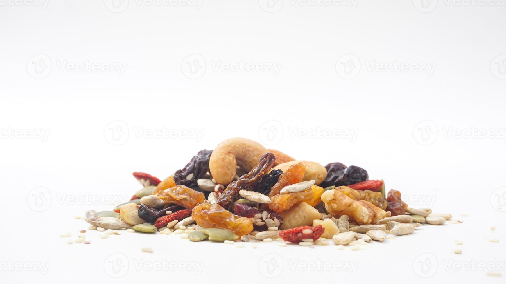 Delicious combination of nuts seeds and dried fruits isolated on white background photo