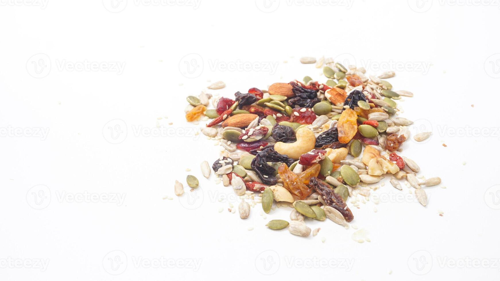 Selection of mixed nuts seeds and dried fruits isolated on white background photo