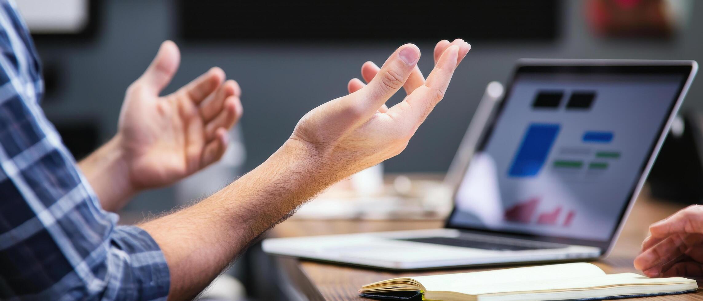 Two people are sitting at a table with their hands up photo