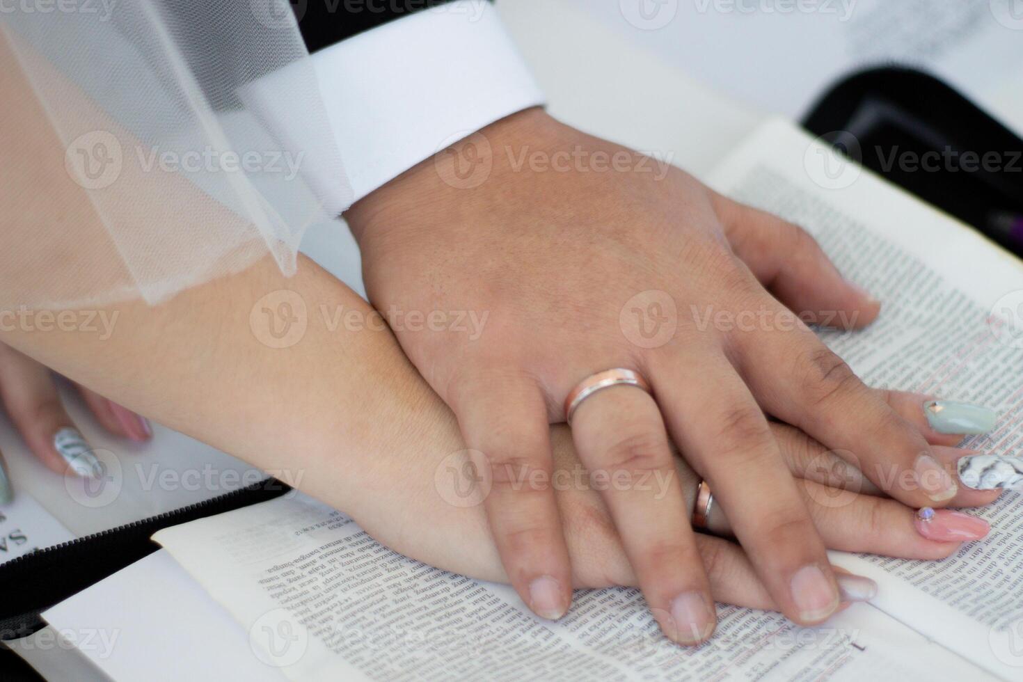 Hands of a couple during a wedding ceremony with rings photo