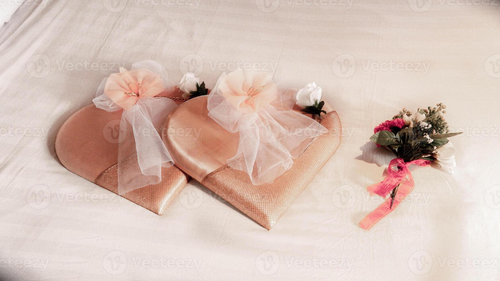 Romantic wedding decoration with heart-shaped pillows and flowers on a bed photo