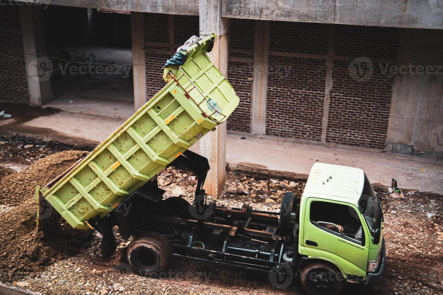 Green Dump Truck Unloading Dirt photo