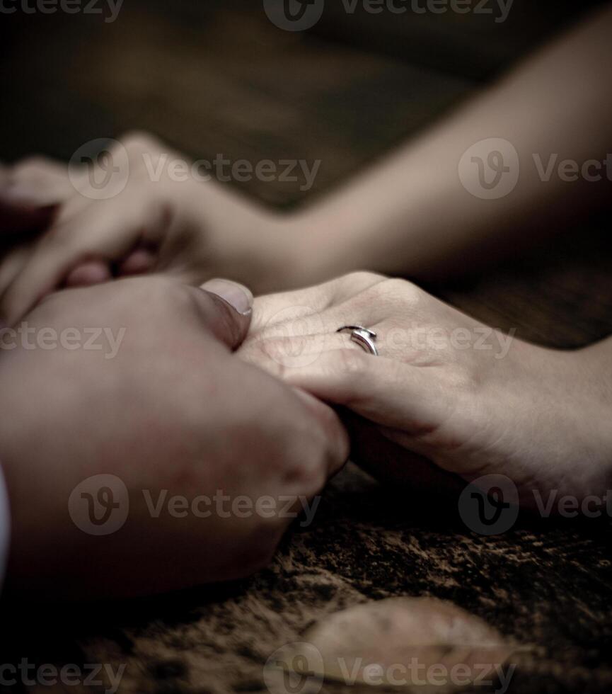 Couple holding hands with an engagement ring photo