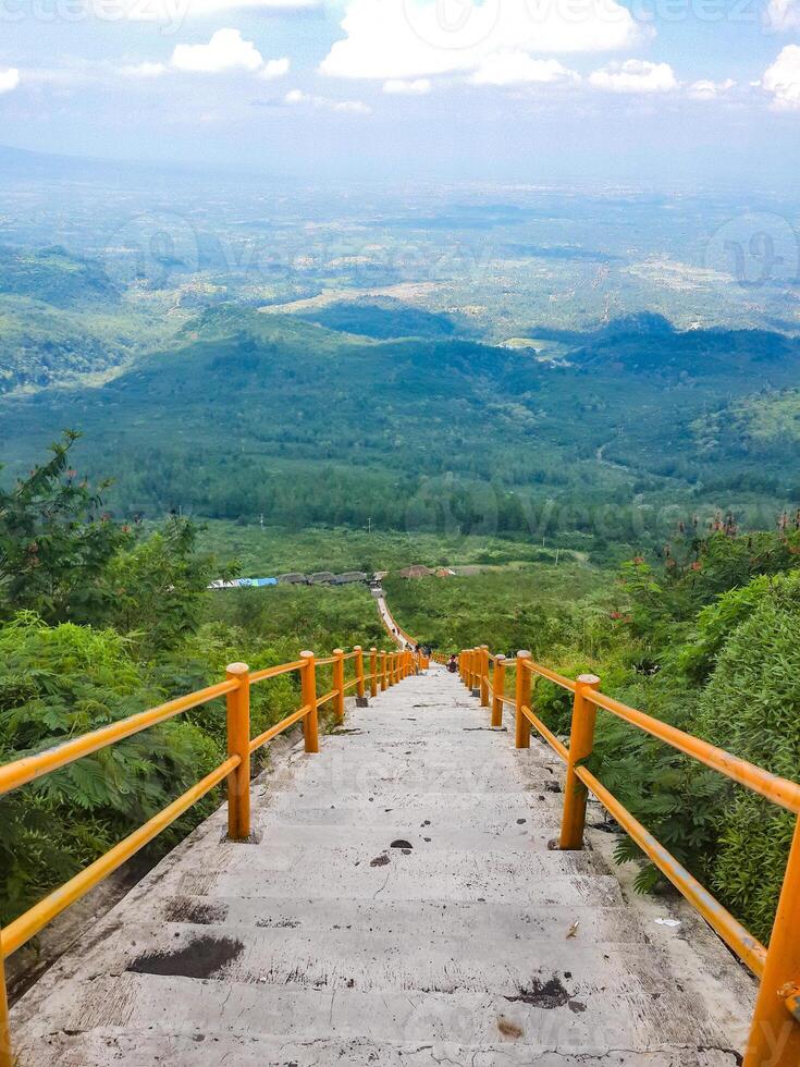 Stairway to a breathtaking view of the green hills and open sky. photo