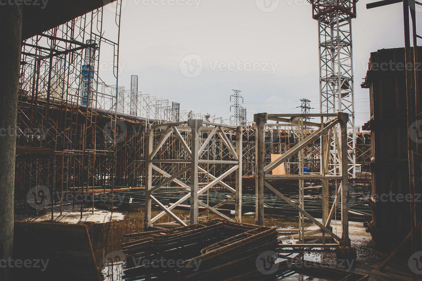 Construction site with scaffolding and steel structures against a cloudy sky photo