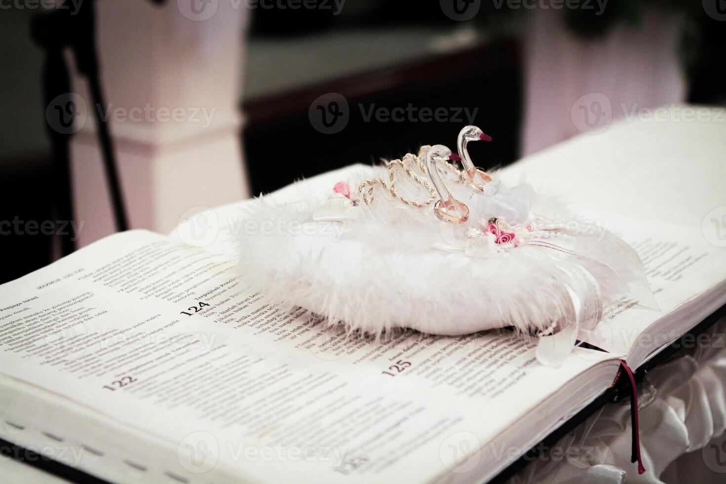 Swan Ring Pillow on a Holy Book for Wedding Ceremony photo