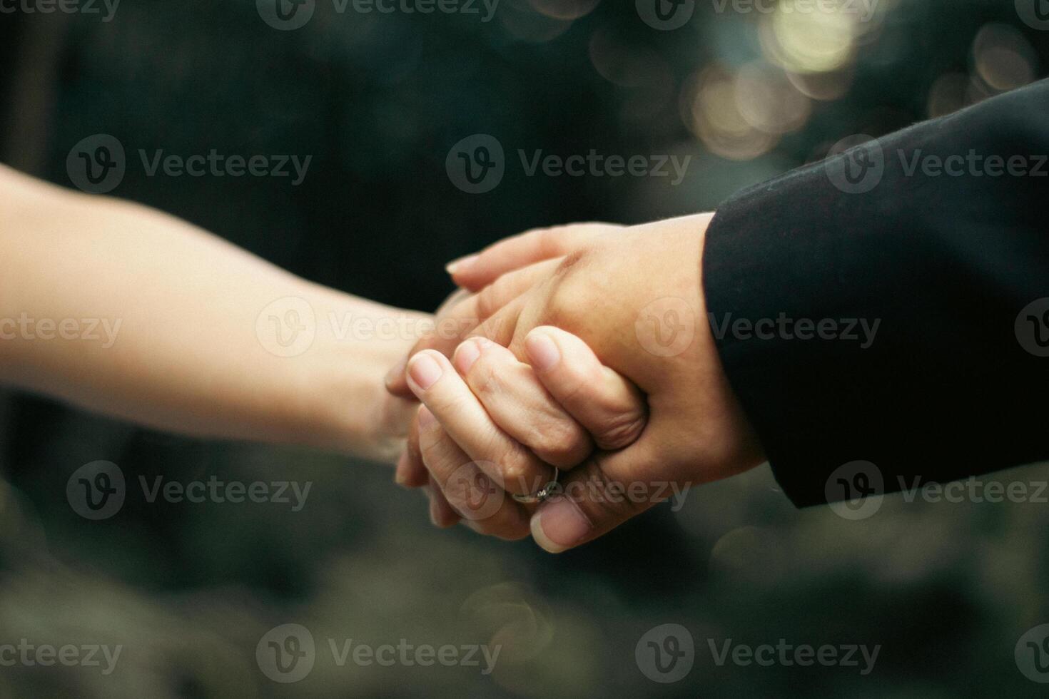 Close-up of a couple holding hands with wedding ring, symbolizing love and connection photo