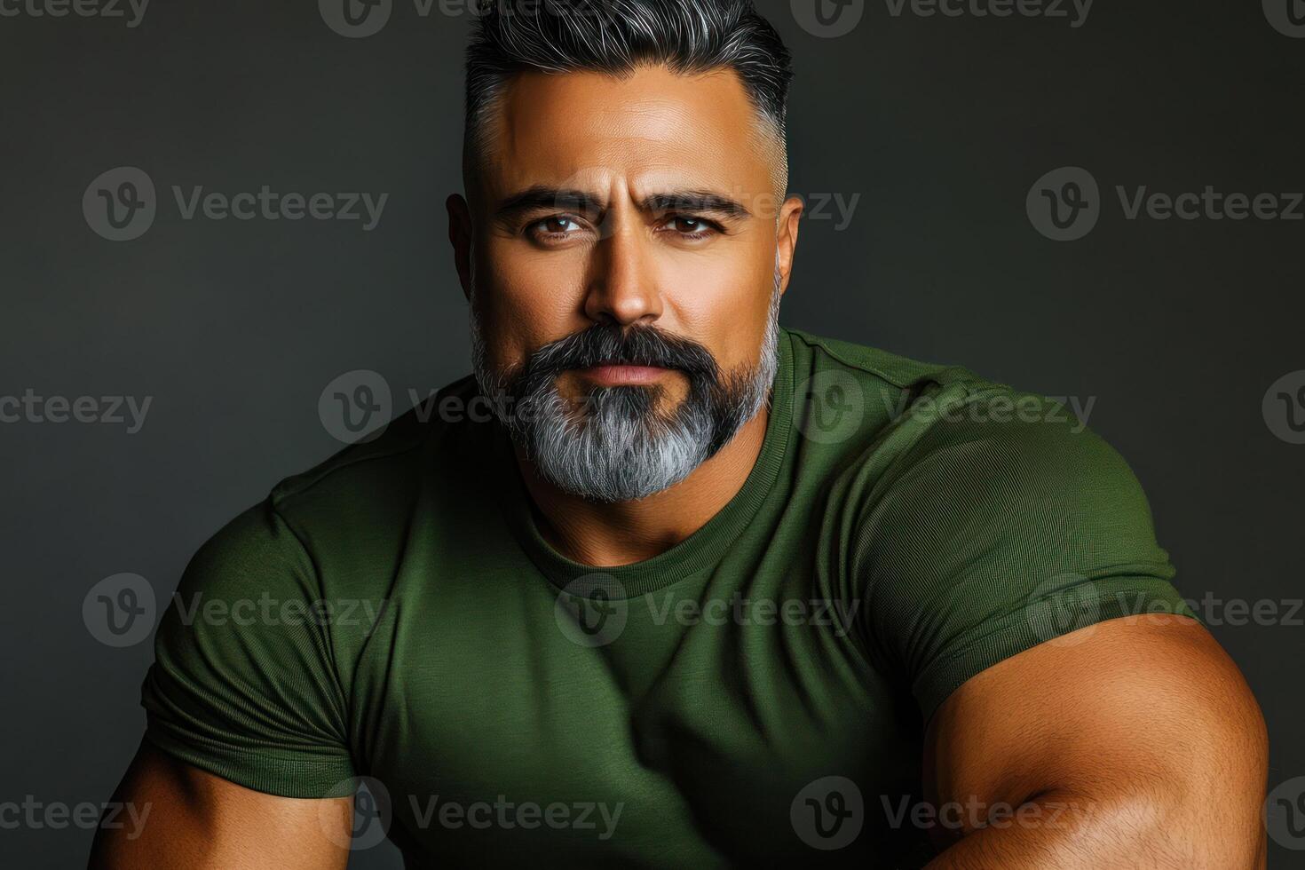 Strong man posing with a confident expression against a dark background photo