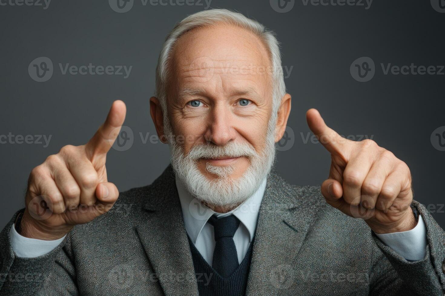 Smiling older man with a beard points at the camera in a well-fitted suit and blazer photo