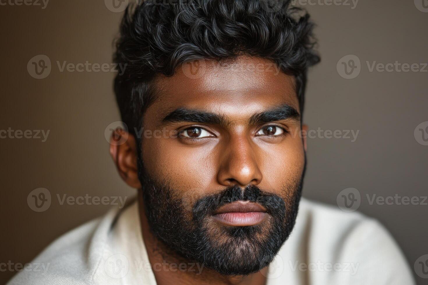 Portrait of a young man with curly hair and strong features against a neutral background photo