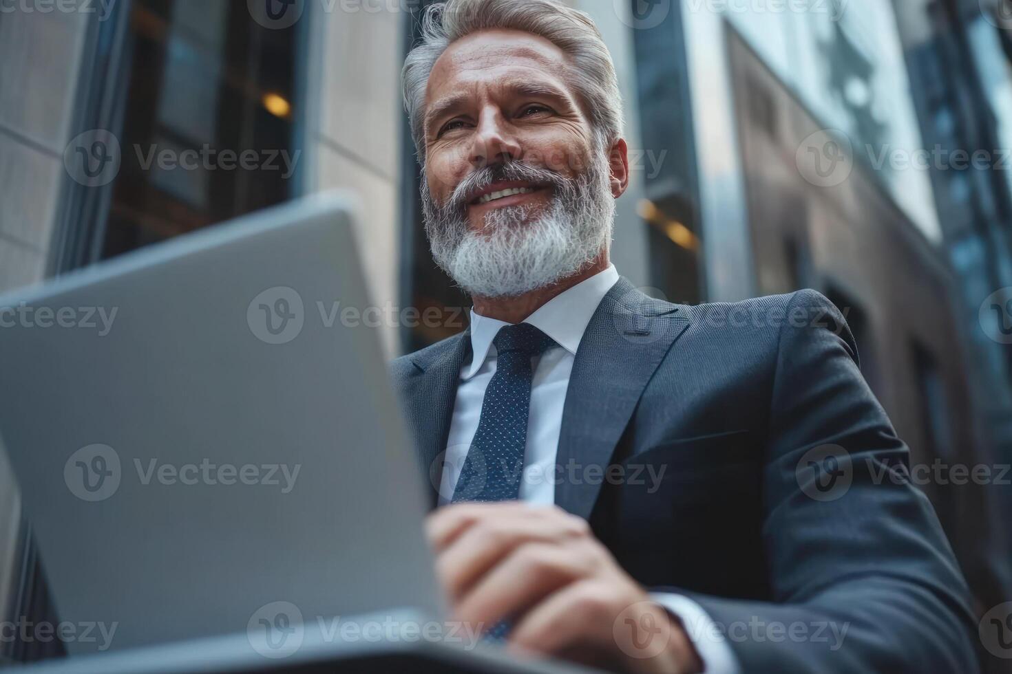 Business professional smiling while working on a laptop in an urban setting during the daytime photo