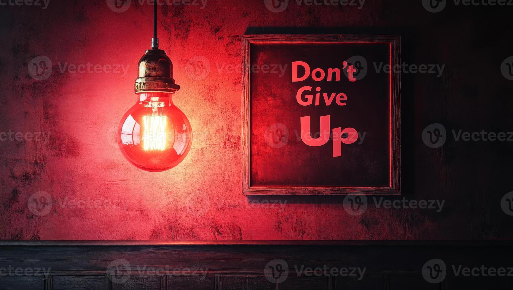 Red lightbulb illuminating a motivational poster with the phrase don't give up hanging on a grungy red wall photo