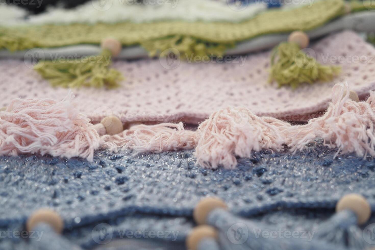 Colorful handmade textiles with fringes and beads on display photo