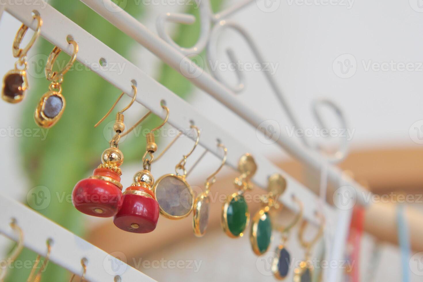 Beautifully crafted earrings displayed on a decorative stand photo