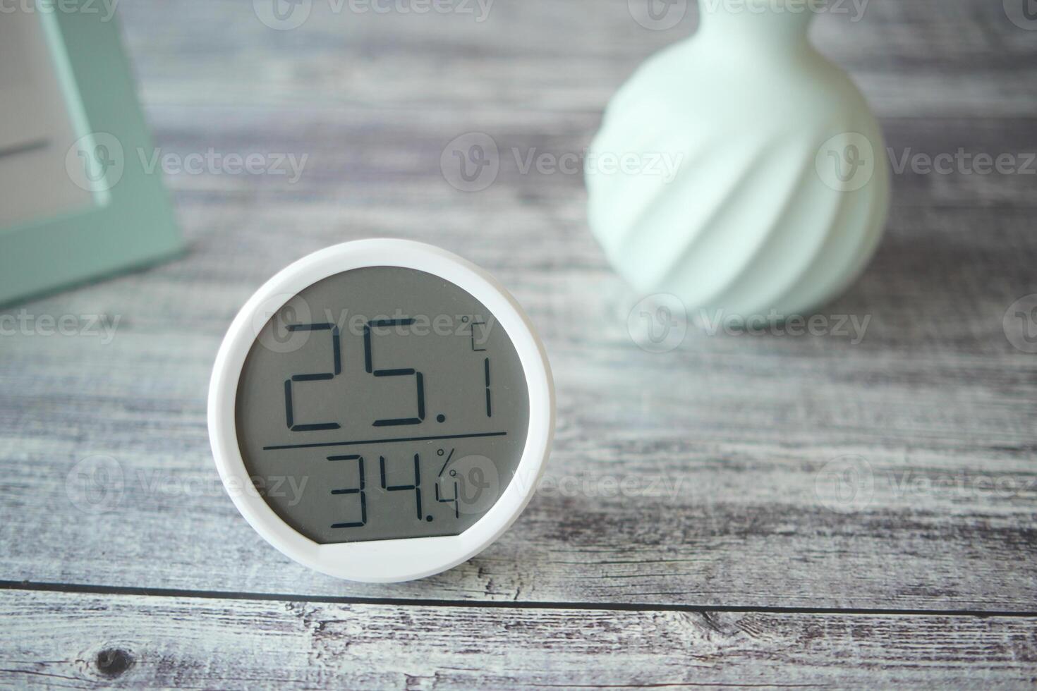 Room temperature and humidity monitor on wooden table photo