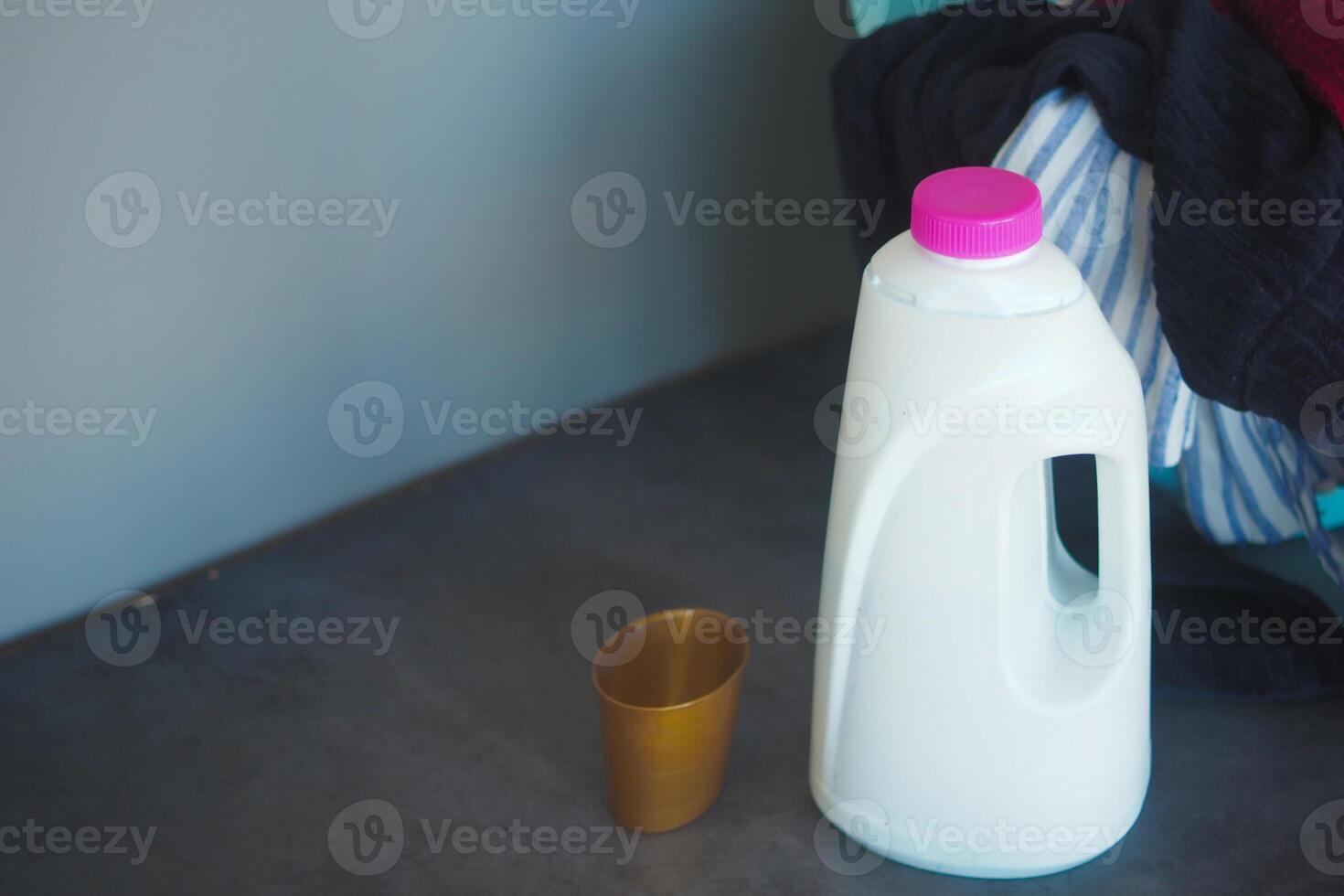 Milk jug and a cup placed on a dark table in a cozy setting photo