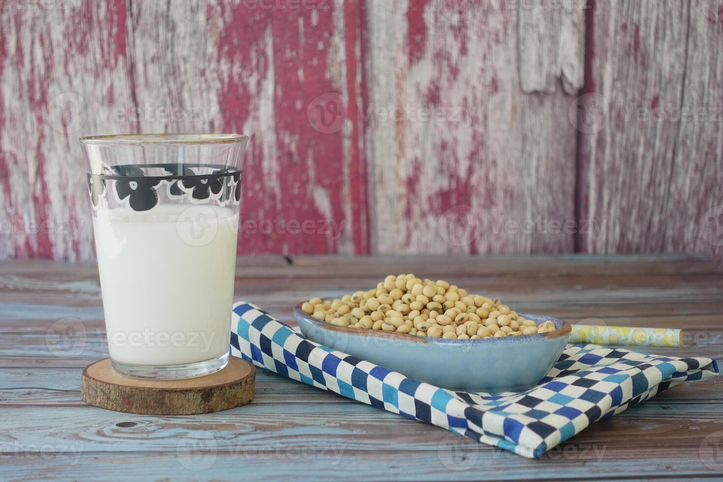 Soy milk in a glass with soybeans on a rustic wooden table photo