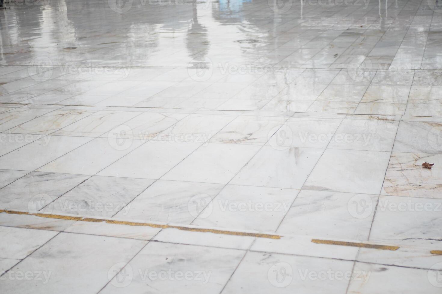 Wet marble floor reflecting light in a quiet indoor space photo