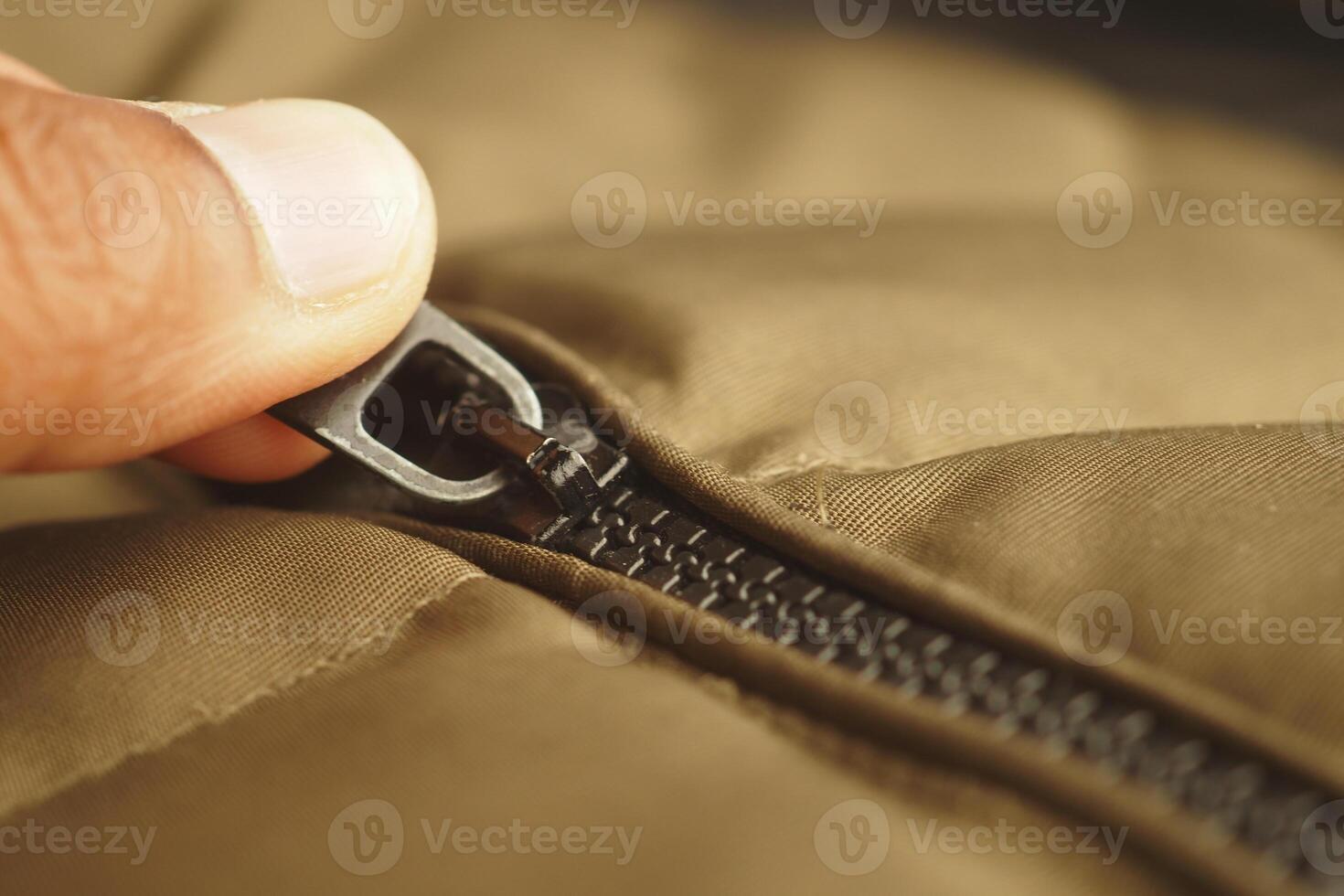 Zipper being pulled on a brown jacket in a cozy setting photo